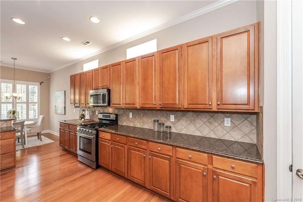 872 Treasure Court Fort Mill, SC 29708 - Photo 12 of 42 a kitchen with stainless steel appliances granite countertop a stove a sink dishwasher and a refrigerator with wooden floor