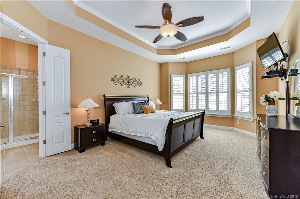 872 Treasure Court Fort Mill, SC 29708 - Photo 19 of 42 a spacious bedroom with a bed and a flat tv screen on dresser