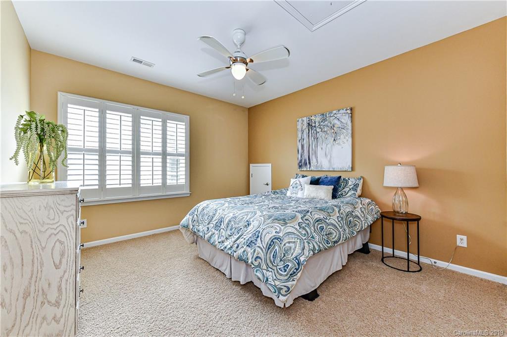872 Treasure Court Fort Mill, SC 29708 - Photo 25 of 42 a spacious bedroom with a bed and a chandelier