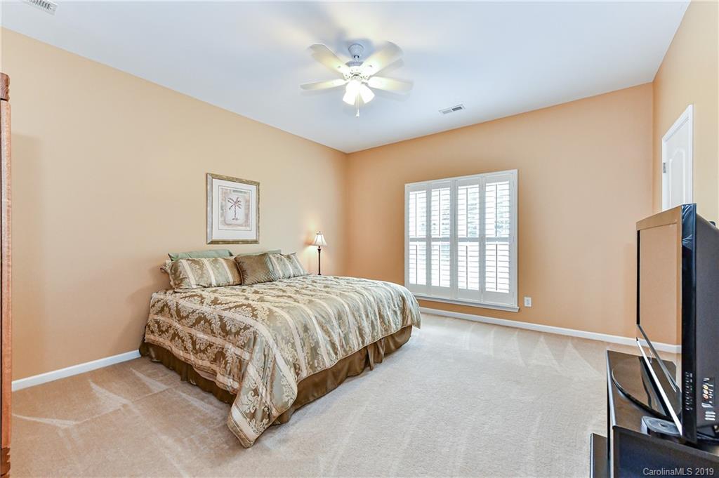 872 Treasure Court Fort Mill, SC 29708 - Photo 35 of 42 a spacious bedroom with a bed a window and a flat screen tv