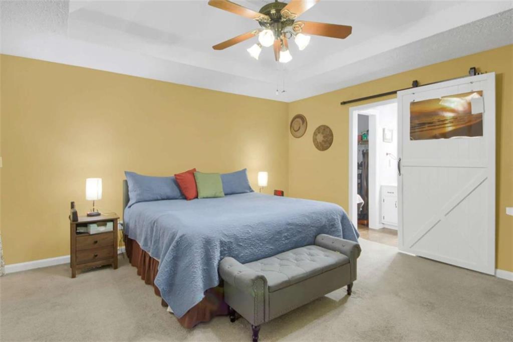 112 Bridget Drive Hampton, GA 30228 - Photo 14 of 26 a bedroom with a bed and a chandelier