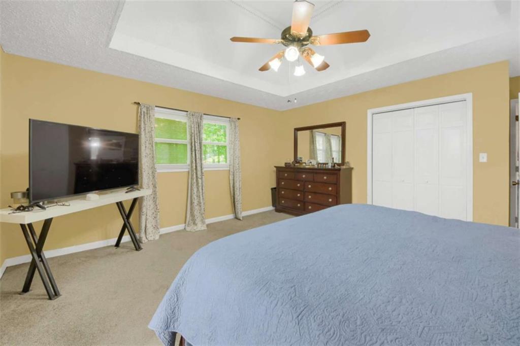 112 Bridget Drive Hampton, GA 30228 - Photo 15 of 26 a bedroom with a bed and a flat screen tv