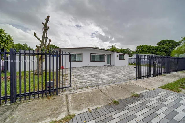 a view of house with backyard and plants