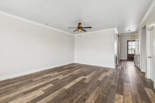 a view of a livingroom with wooden floor and a ceiling fan