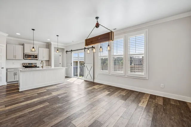 a view of kitchen with wooden floor and electronic appliances