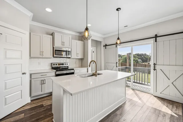 a kitchen with kitchen island a sink appliances cabinets and a counter top space