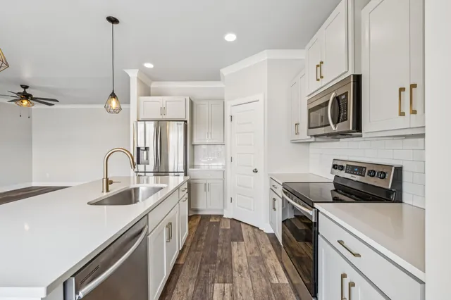 a kitchen with stainless steel appliances granite countertop a sink a stove and a refrigerator