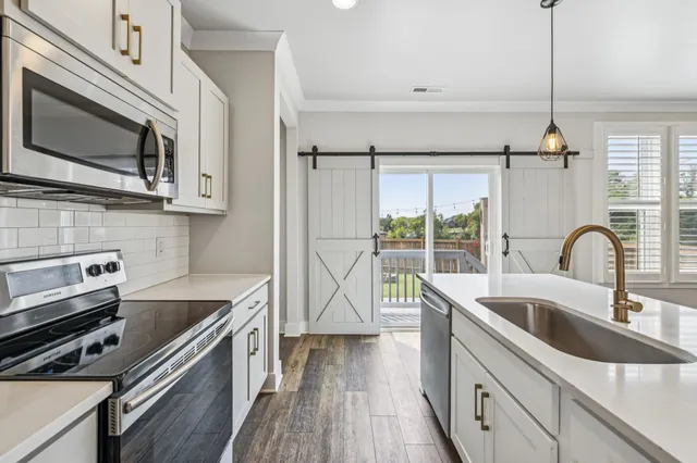 a kitchen with a sink a stove and cabinets