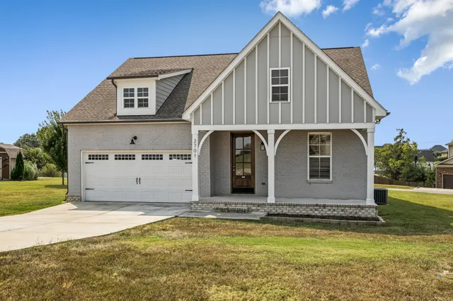 a front view of house with yard and garage