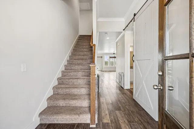 a view of a hallway with wooden floor and entryway