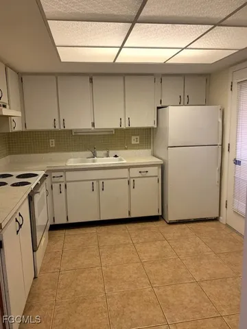 a kitchen with a sink a refrigerator and cabinets