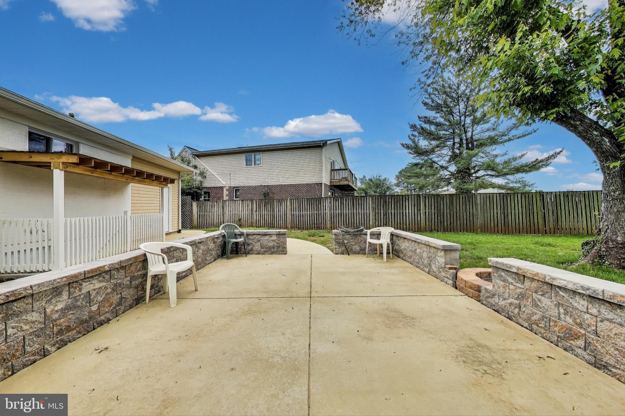 2500 Gehb Avenue Baltimore, MD 21227 - Photo 4 of 53 a view of a patio with table and chairs with wooden fence and a large tree