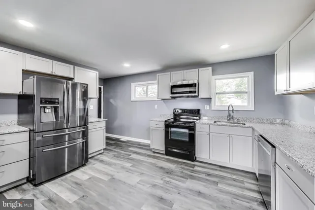 a kitchen with a sink stove top oven and cabinets