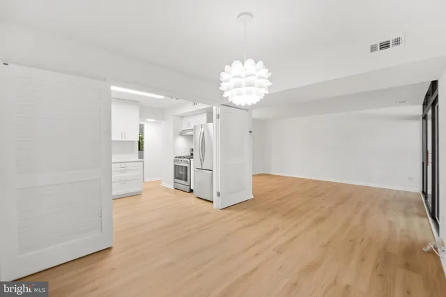 wooden floor in an empty room with a chandelier
