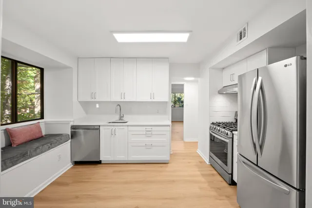 a kitchen with white cabinets and stainless steel appliances