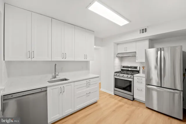 a kitchen with stainless steel appliances granite countertop a refrigerator sink and stove