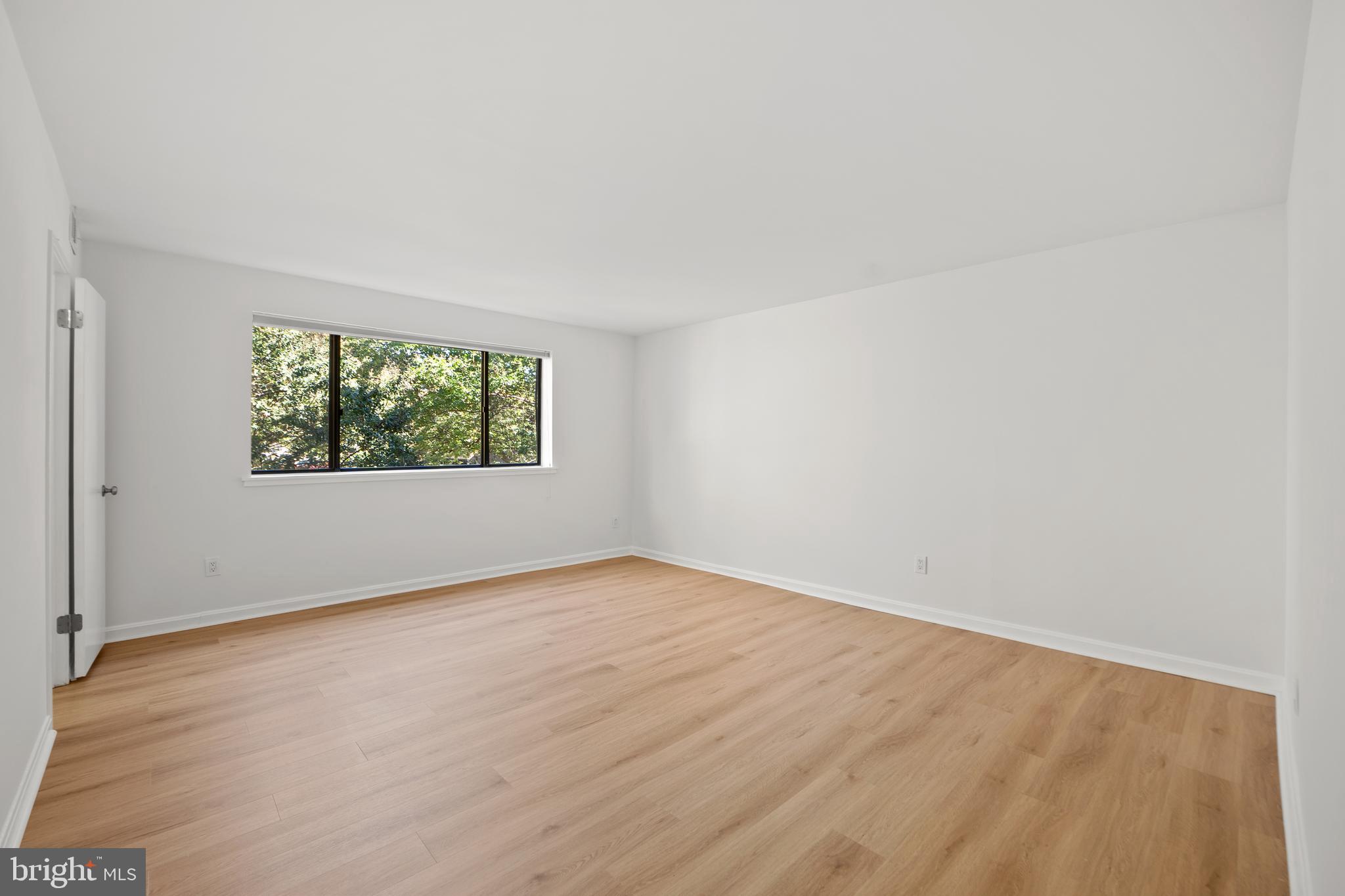 1656 Parkcrest Circle, Unit 2D/301 Reston, VA 20190 - Photo 17 of 29 an empty room with wooden floor and windows
