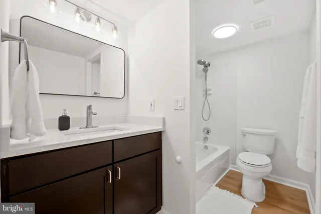 a bathroom with a toilet a sink a mirror and shower