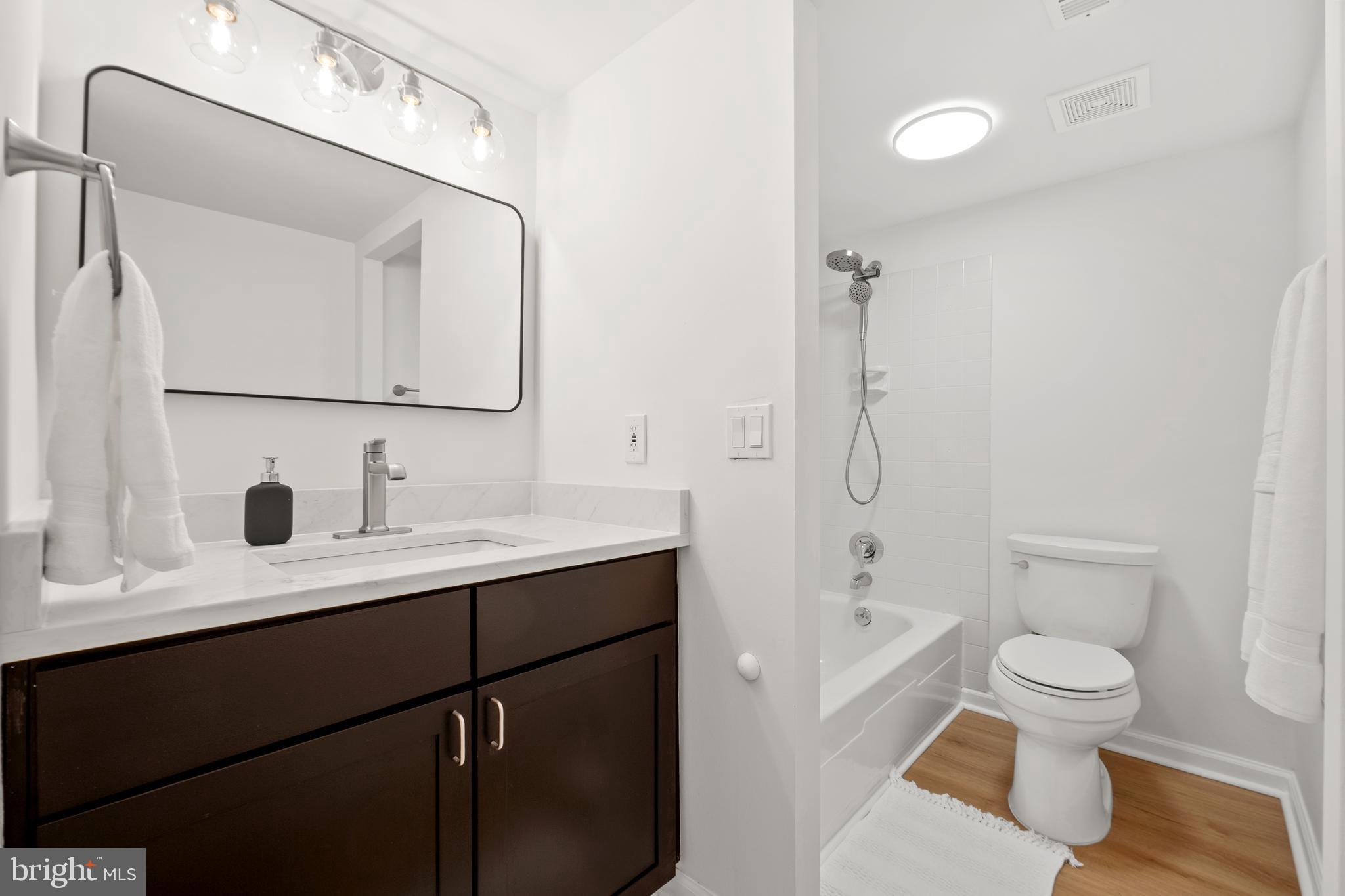 1656 Parkcrest Circle, Unit 2D/301 Reston, VA 20190 - Photo 20 of 29 a bathroom with a toilet a sink a mirror and shower