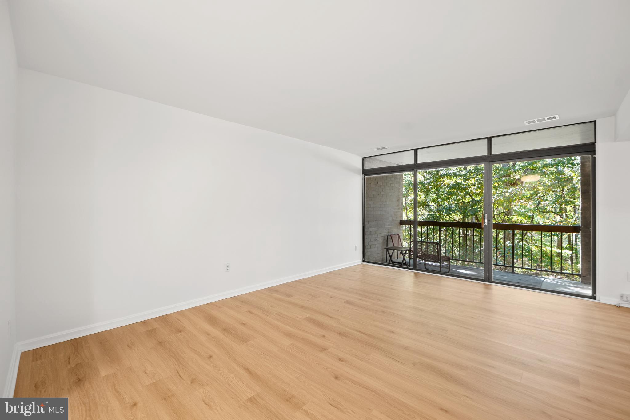 1656 Parkcrest Circle, Unit 2D/301 Reston, VA 20190 - Photo 5 of 29 a view of an empty room with wooden floor and a window