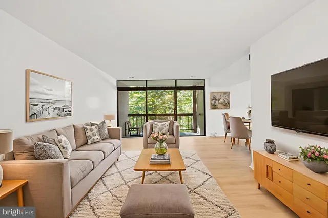 a living room with furniture large window and a flat screen tv