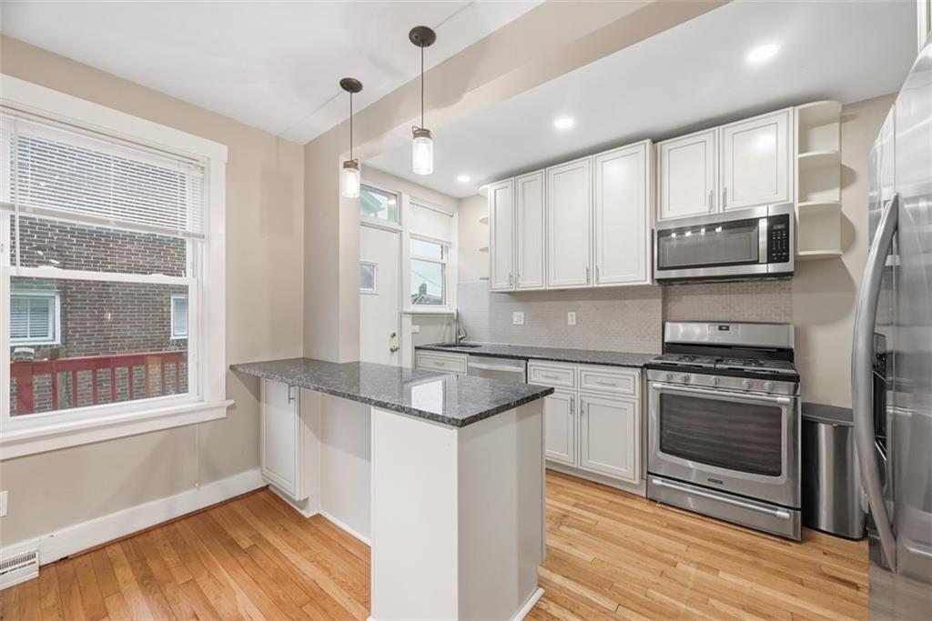 436 44th Street Pittsburgh, PA 15201 - Photo 11 of 30 a kitchen with stainless steel appliances granite countertop a stove a sink and a microwave