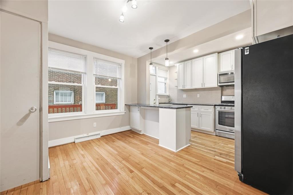 436 44th Street Pittsburgh, PA 15201 - Photo 12 of 30 a kitchen with a refrigerator and white cabinets