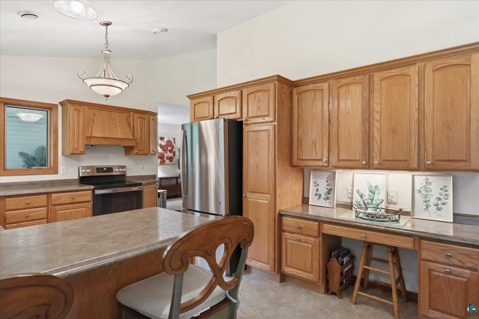 41 East Stark Road Esko, MN 55733 - Photo 6 of 19 Spacious kitchen featuring oak cabinetry, stainless steel appliances, a center island with countertop seating, a built-in desk area, and recessed lighting