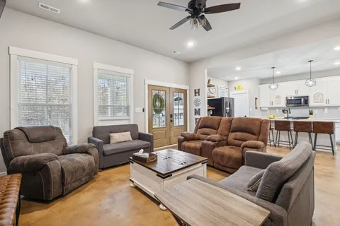 a kitchen with stainless steel appliances kitchen island granite countertop a sink a stove a refrigerator cabinets and chairs