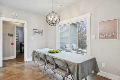a view of a dining room with furniture a chandelier and wooden floor