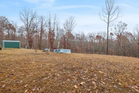 a view of a house with a backyard space and a wooden bench