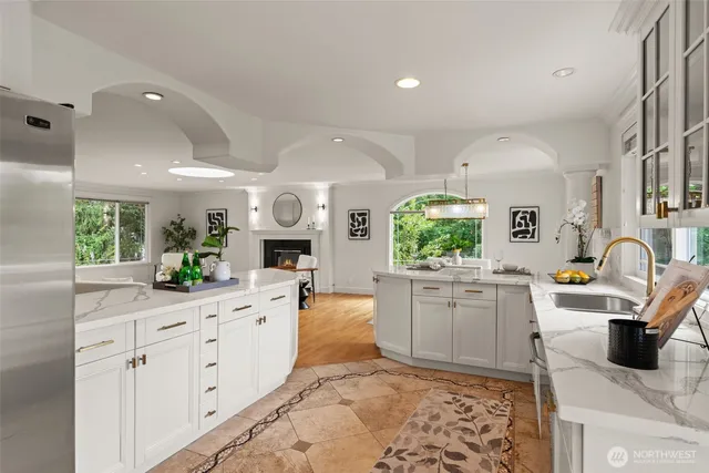a kitchen with stainless steel appliances kitchen island granite countertop a refrigerator and sink