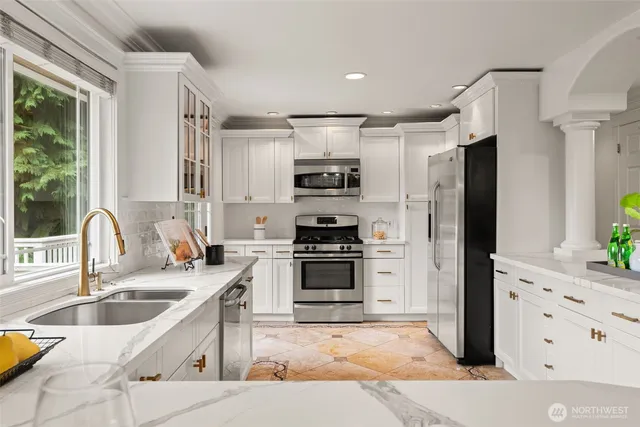 a kitchen with granite countertop a sink stainless steel appliances and cabinets