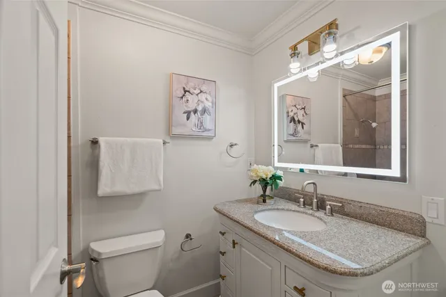 a bathroom with a granite countertop sink mirror and toilet