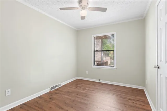 an empty room with a window and wooden floor