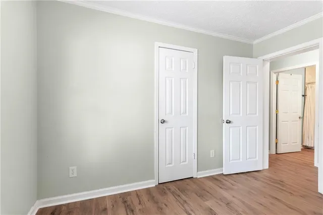 an empty room with wooden floor & windows