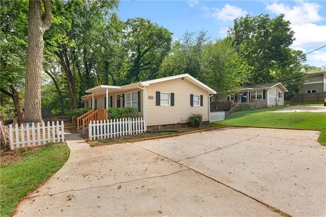 a view of a house with a yard and fence