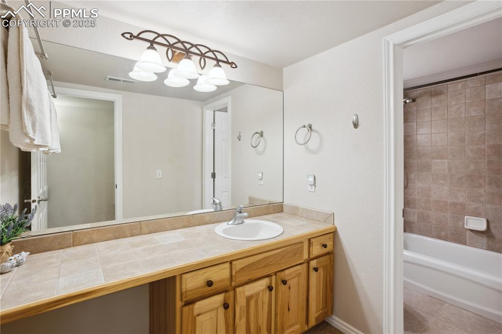 16243 Kitchener Way Monument, CO 80132 - Photo 21 of 33 a bathroom with a granite countertop sink a mirror and a bathtub