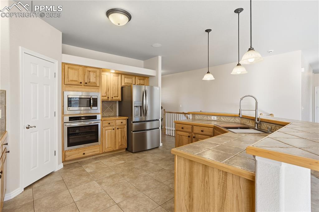 16243 Kitchener Way Monument, CO 80132 - Photo 6 of 33 a kitchen with refrigerator a stove and a sink