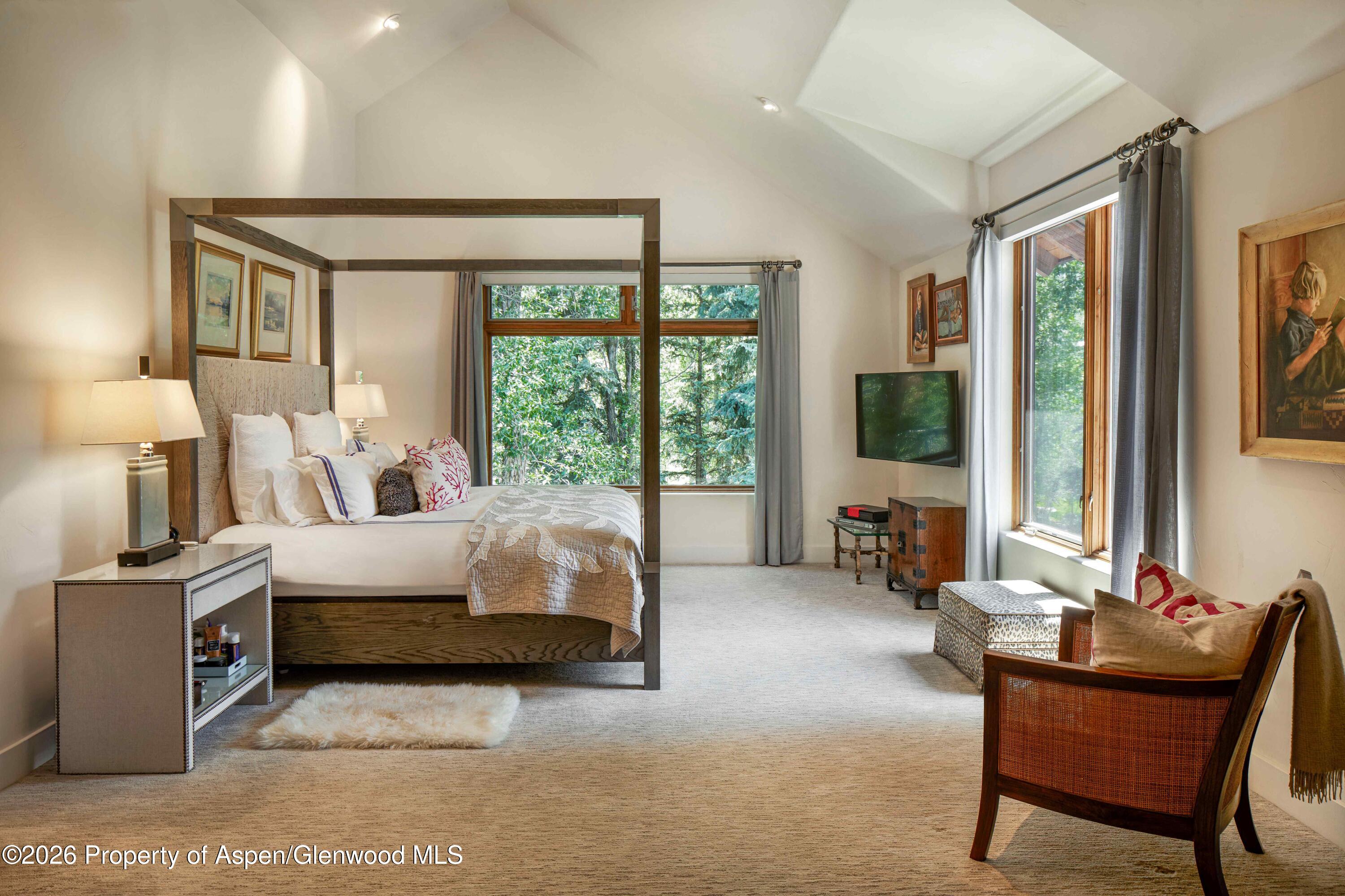 256 Twining Flats Road Aspen, CO 81611 - Photo 15 of 38 a bed room with a bed and a flat tv screen