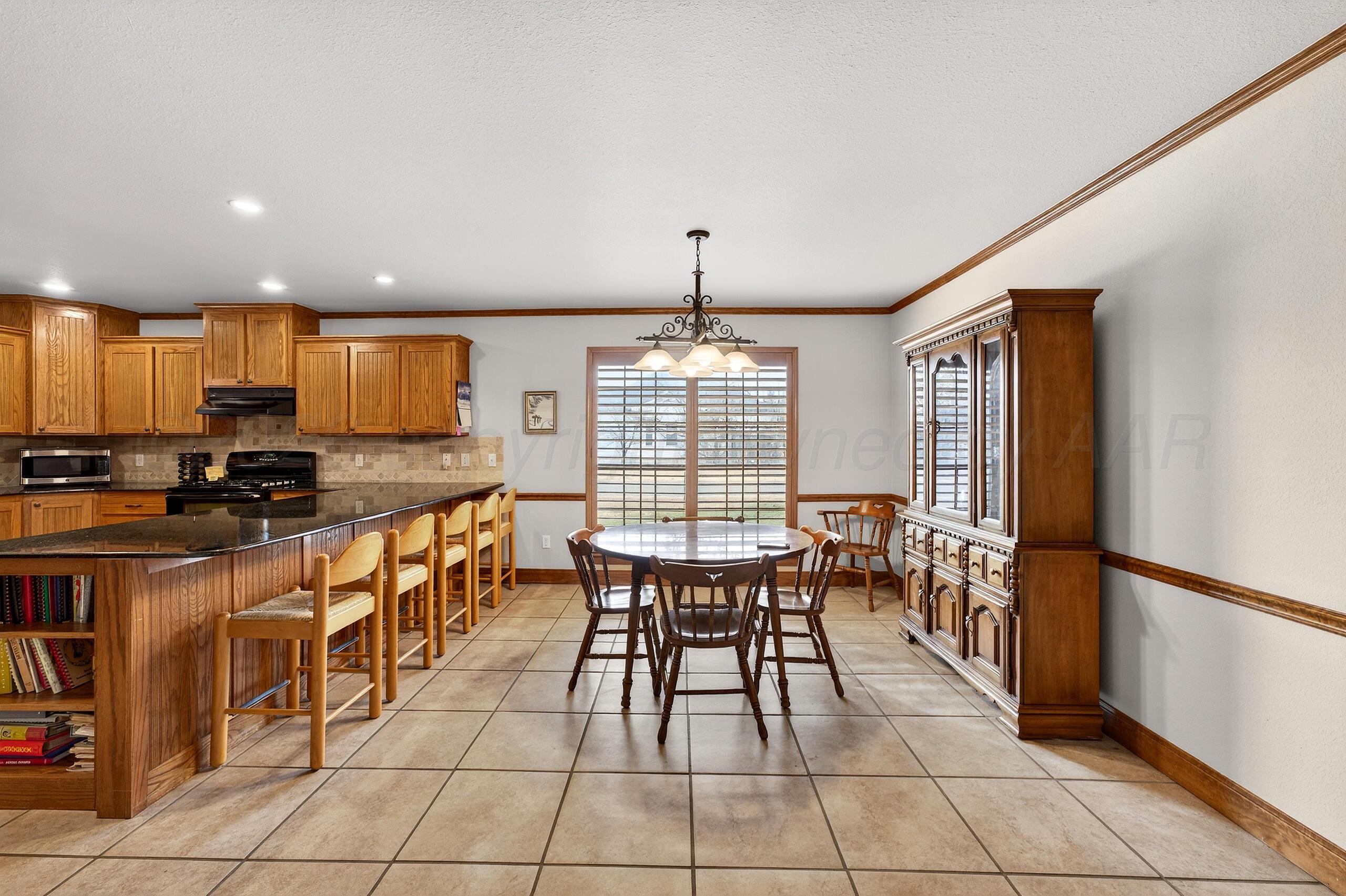 312 Dysart Street Claude, TX 79019 - Photo 15 of 37 a open kitchen with stainless steel appliances granite countertop a stove top oven a sink dishwasher a dining table and chairs with wooden floor
