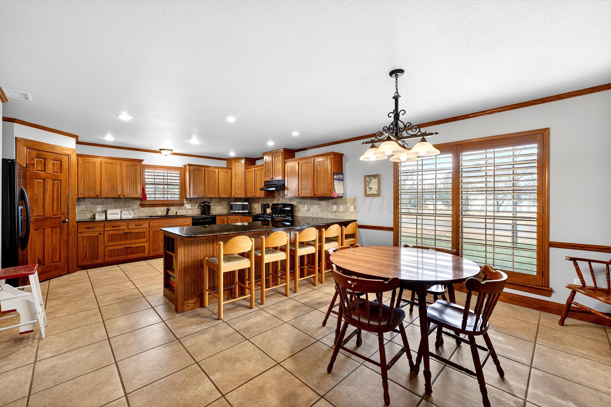 312 Dysart Street Claude, TX 79019 - Photo 16 of 37 a room with stainless steel appliances kitchen island granite countertop a dining table chairs and white cabinets