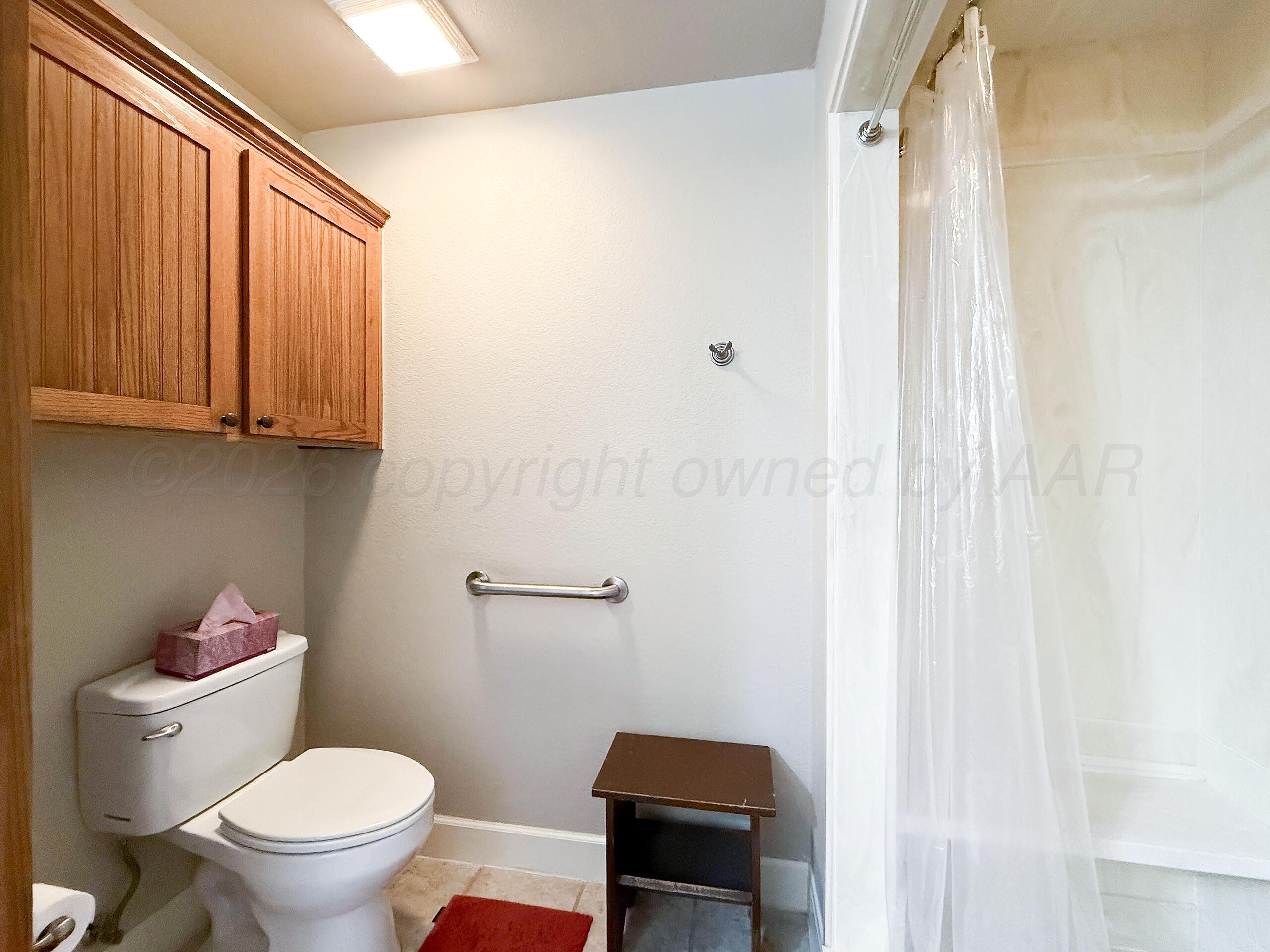 312 Dysart Street Claude, TX 79019 - Photo 22 of 37 a white toilet sitting next to a bathroom sink and a shower