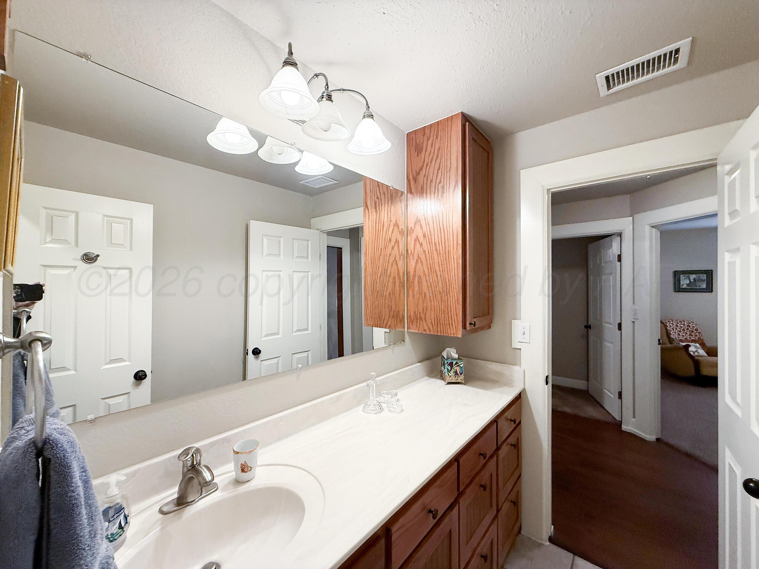 312 Dysart Street Claude, TX 79019 - Photo 28 of 37 a bathroom with a sink double vanity granite and a mirror
