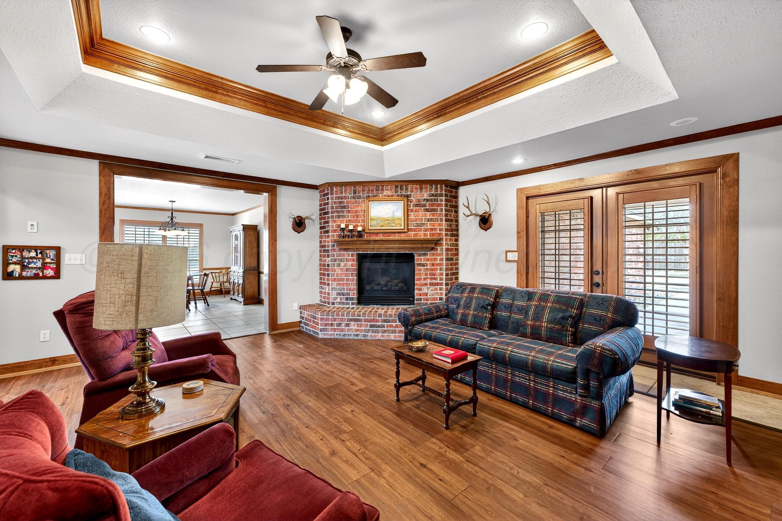 312 Dysart Street Claude, TX 79019 - Photo 4 of 37 a living room with furniture a ceiling fan a fireplace and a large window