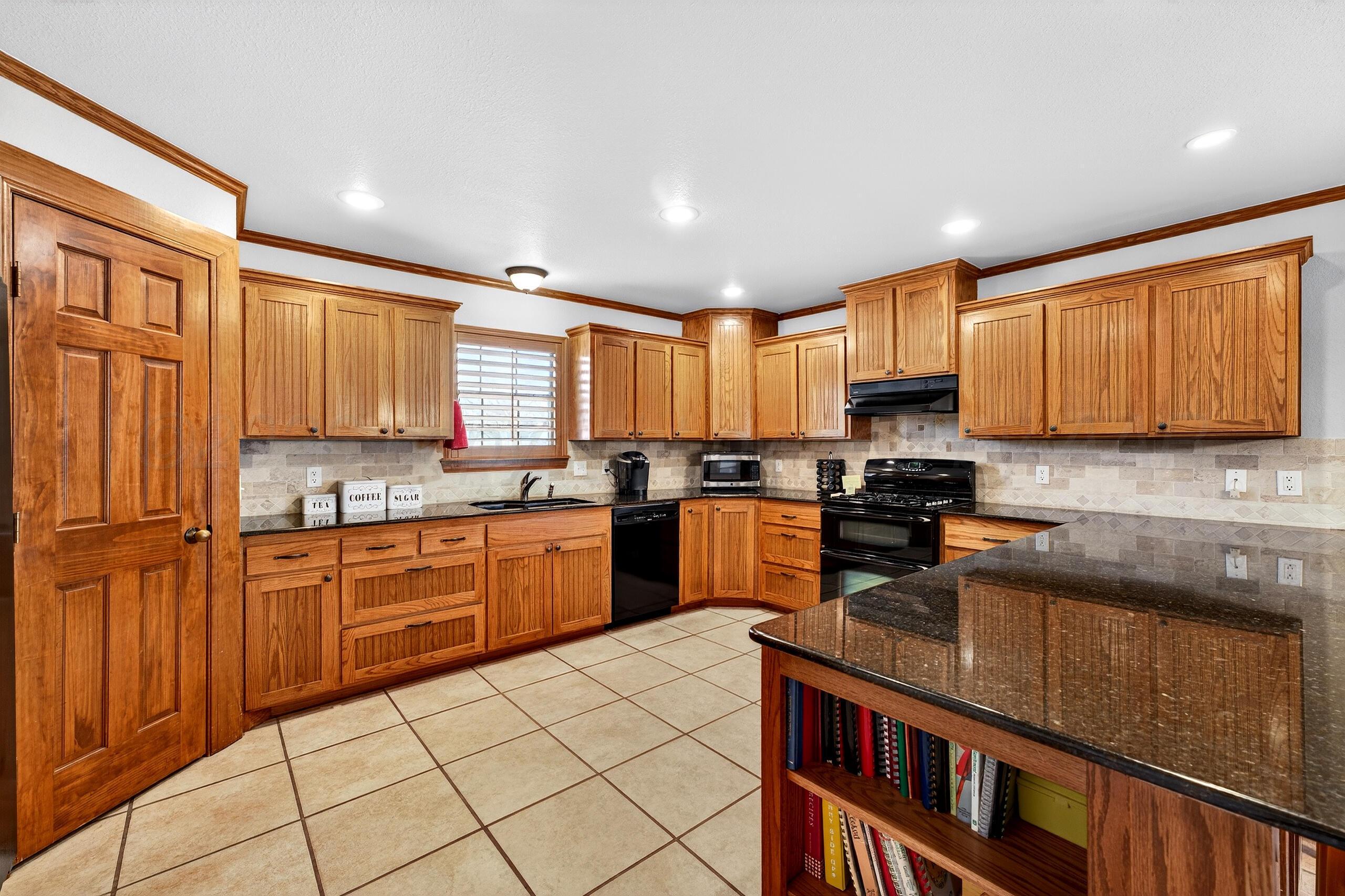 312 Dysart Street Claude, TX 79019 - Photo 9 of 37 a kitchen with stainless steel appliances granite countertop a stove sink and cabinets