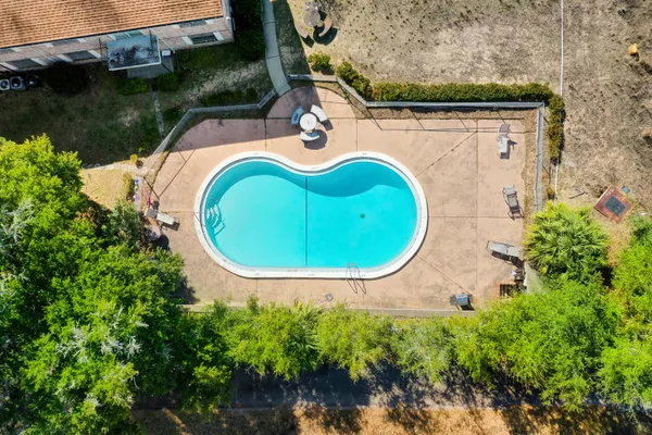 an aerial view of a house with a swimming pool and outdoor space