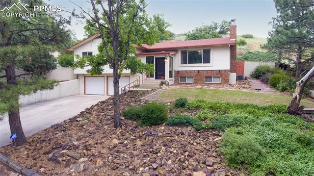 a view of a house with backyard sitting area and garden