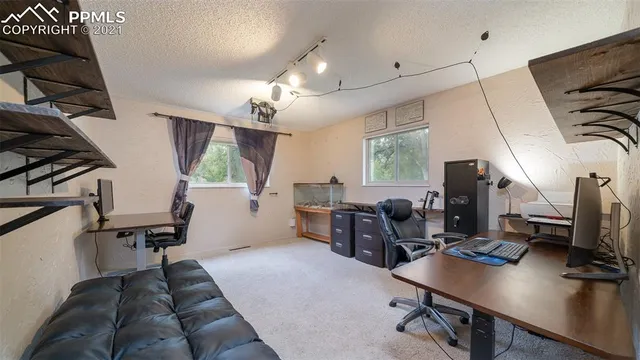 a view of a workspace with furniture and a window