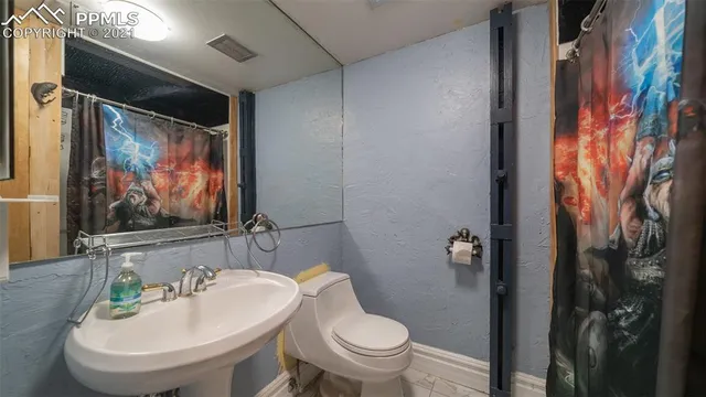 a view of backyard with wooden fence and large trees